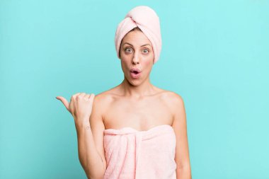 pretty blonde woman looking astonished in disbelief. bathrobe and beauty concept