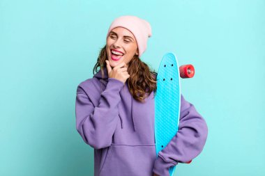 Mutlu, kendine güvenen, elleri çenesinde gülümseyen İspanyol güzel kadın. kaykay konsepti