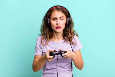 hispanic pretty young woman playing with headphones and a control. gamer concept