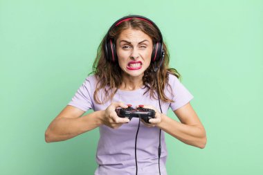 hispanic pretty young woman playing with headphones and a control. gamer concept