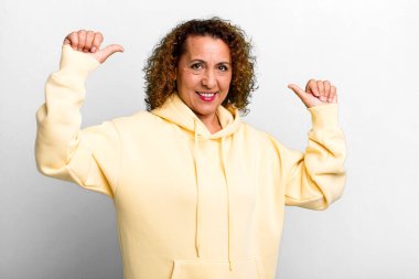 Orta yaşlı İspanyol kadın gururlu, kibirli ve kendinden emin, tatmin olmuş ve başarılı görünüyor, kendini işaret ediyor.