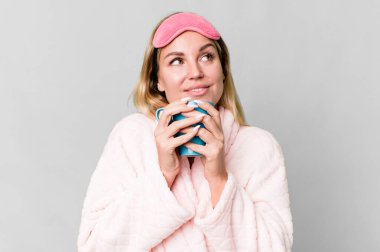 pretty caucasian woman wearing night wear and having a coffee cup for breakfast clipart