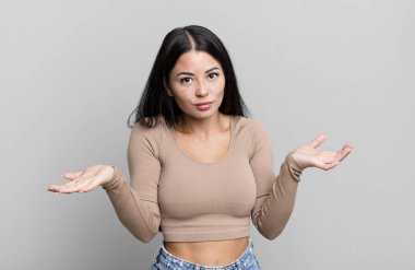 pretty latin woman feeling puzzled and confused, unsure about the correct answer or decision, trying to make a choice