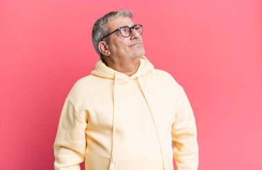 Endişeli, kafası karışık, budala bir ifadeyle orta yaşlı bir adam kopyalama alanına bakıyor, şüphe duyuyor.