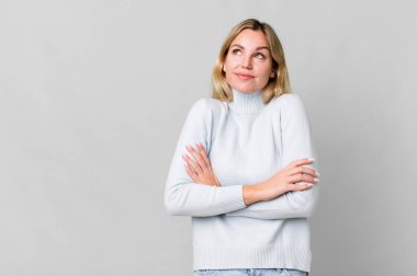 caucasian blonde woman shrugging, feeling confused and uncertain. copy space concept
