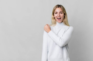 caucasian blonde woman feeling happy and facing a challenge or celebrating. copy space concept