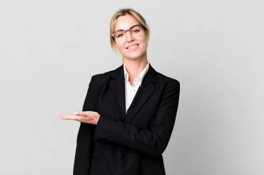 caucasian blonde woman smiling cheerfully, feeling happy and showing a concept. business concept