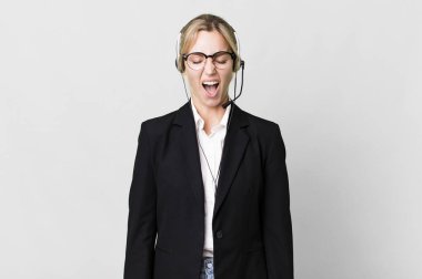 caucasian blonde woman shouting aggressively, looking very angry. telemarketing cocnept