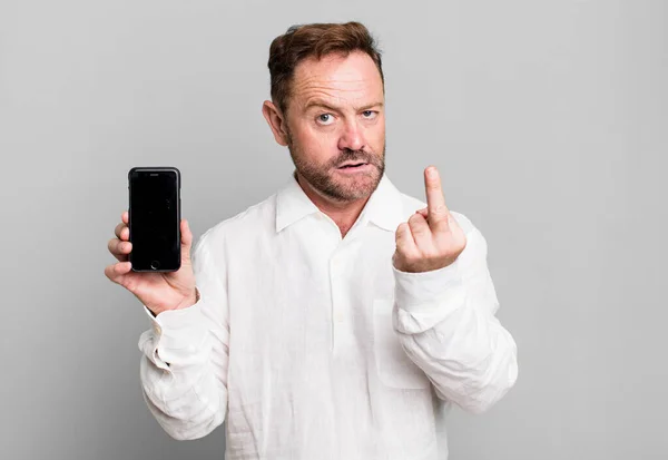 中年男性の怒り いらいら 反抗的で積極的な感じ スマートフォンを見せると — ストック写真