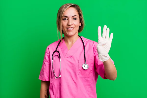 Pretty Blonde Woman Smiling Looking Friendly Showing Number Four Nurse — Stock Photo, Image