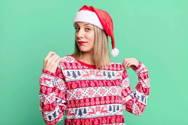 pretty blonde woman looking arrogant, successful, positive and proud. christmas and santa hat concept