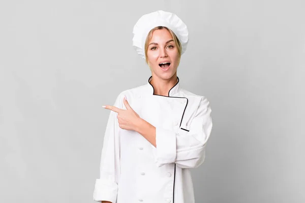 Caucasian Blonde Woman Looking Excited Surprised Pointing Side Chef Concept — Zdjęcie stockowe