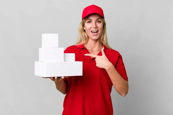 Caucasian Blonde Woman Looking Excited Surprised Pointing Side Delivery Boxes — Stok fotoğraf