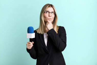 young pretty woman thinking, feeling doubtful and confused. presenter or journalist concept