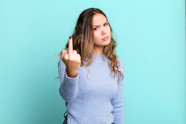 Genç ve güzel bir kadın kızgın, sinirli, isyankar ve agresif hissediyor, orta parmağını sallıyor, karşı koyuyor.