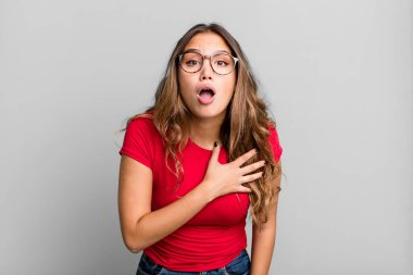 Genç ve güzel bir kadın şok olmuş ve şaşırmış hissediyor, gülümsüyor, el ele tutuşuyor, o kişi olmaktan mutlu ya da minnettarlık gösteriyor.