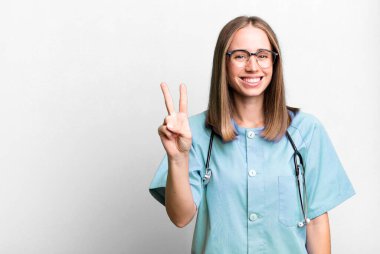 Gülümsüyor ve dost canlısı görünüyor, iki numarayı gösteriyor. hemşire konsepti