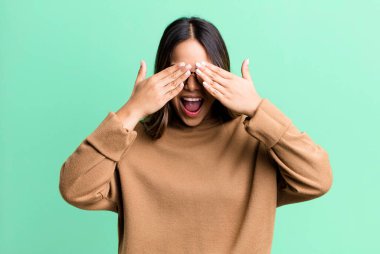 İspanyol güzel kadın gülümsüyor ve mutlu hissediyor, iki eliyle gözlerini kapatıyor ve inanılmaz bir sürpriz bekliyor.