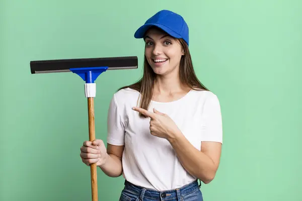 Young Pretty Woman Looking Excited Surprised Pointing Side Cleaning Windows — Stockfoto