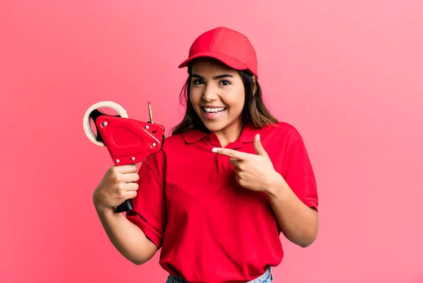 Hispanic Pretty Woman Looking Excited Surprised Pointing Side Packer Delivery — Foto Stock