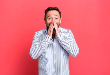 Mutlu, neşeli, şanslı ve şaşkın görünüyor iki eliyle ağzını kapatıyor.