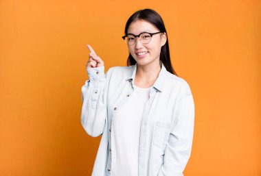 Genç, güzel, Asyalı, etkileyici bir kadın. Yanında fotokopi odası var.