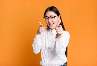 Genç, güzel, Asyalı, etkileyici bir kadın. Yanında fotokopi odası var.