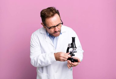 Orta yaşlı bir adam. Futbol topuyla bilim adamı konsepti spor koçu konsepti