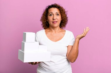 pretty middle age woman feeling happy, surprised realizing a solution or idea. blank white boxes packaging