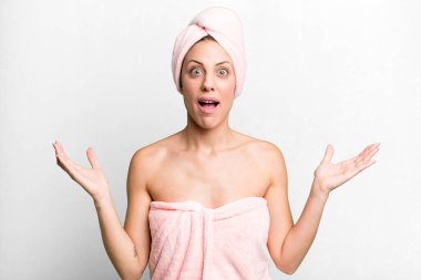 pretty blonde woman feeling happy and astonished at something unbelievable. bathrobe and beauty concept