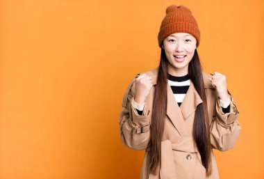 Güzel Asyalı kadın şokta, gülüyor ve başarıyı kutluyor.