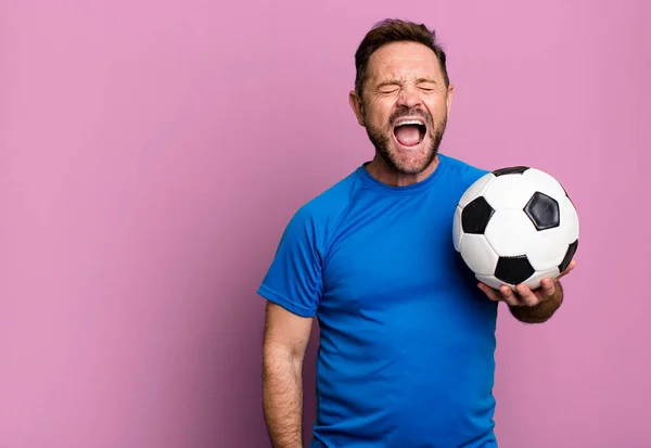 中年男性が積極的に叫び 非常に怒っているように見えます サッカーボールで フィットネスのコンセプト — ストック写真