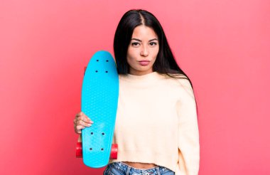 İspanyol güzel bir kadın üzgün ve mızmızlanıyor. Mutsuz bir bakışı var ve ağlıyor. kaykay konsepti