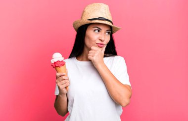 hispanic pretty woman thinking, feeling doubtful and confused. ice cream and summer concept