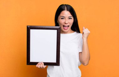 İspanyol güzel kadın şoke olmuş, gülüyor ve boş bir çerçeveyle başarıyı kutluyor.