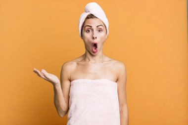 İspanyol güzel kadın şaşırmış ve şok olmuş görünüyor. Ağzında bornoz olan bir nesneyle düşmüş. güzellik konsepti