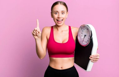 caucasian pretty woman feeling like a happy and excited genius after realizing an idea. fitness and diet concept