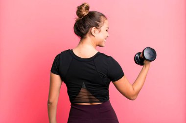hispanic pretty young woman lifting a dumbbell. fitness concept