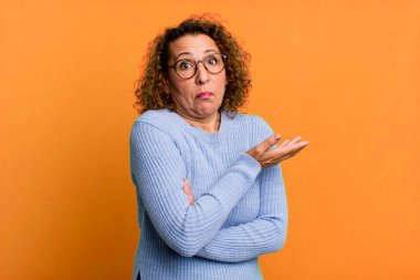 Orta yaşlı İspanyol kadın kafası karışık ve bilgisiz, şüpheli bir açıklama ya da düşünceyi merak ediyor.