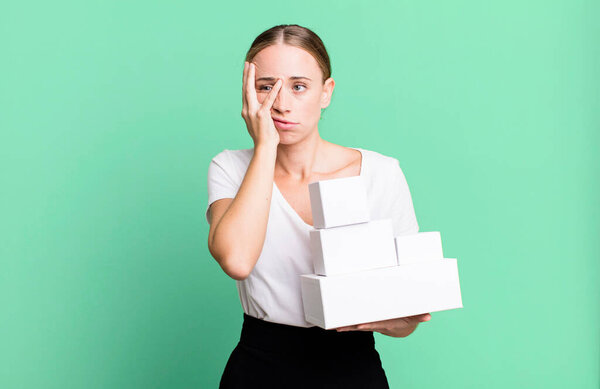 caucasian pretty woman feeling bored, frustrated and sleepy after a tiresome with white boxes packages