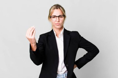 caucasian blonde woman making capice or money gesture, telling you to pay. business concept