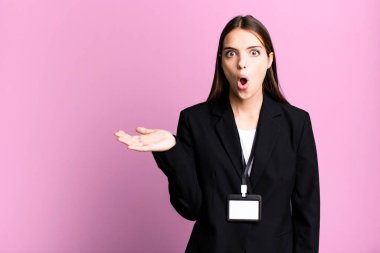 Genç ve güzel bir kadın şaşırmış ve şok olmuş görünüyor. Çenesi düşmüş ve elinde bir nesne tutuyor. İş kadını kavramı