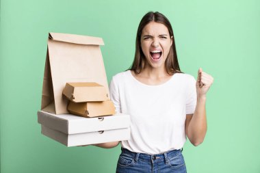 Genç ve güzel bir kadın sinirli bir ifadeyle agresif bir şekilde bağırıyor. teslimat ve paket konsepti