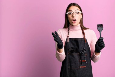 Genç ve güzel bir kadın şok olmuş ve şaşırmış hissediyor. saç kurutma makinesi konsepti