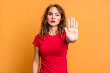 Genç ve güzel bir kadın ciddi, sert, hoşnutsuz ve kızgın görünüyor.