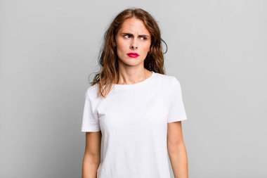 Genç, güzel bir kadın üzgün, üzgün ya da kızgın ve olumsuz bir tavır takınıyor, anlaşmazlık içinde kaşlarını çatıyor.