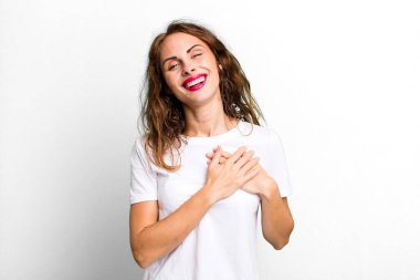 Genç, güzel bir kadın romantik, mutlu ve aşık, neşeyle gülümseyen ve kalbe yakın el ele tutuşan