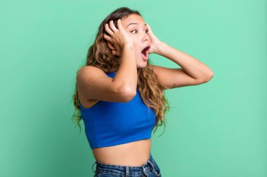 Genç ve güzel bir kadın, ağzı açık, korkunç ve şok olmuş görünüyor, korkunç bir hata yüzünden, el ele tutuşuyor.