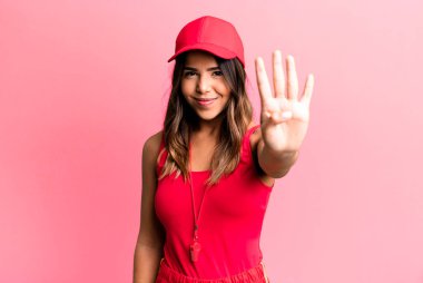 İspanyol güzel kadın gülümsüyor ve arkadaş canlısı görünüyor, dört numaralı spor koçu konseptini gösteriyor.