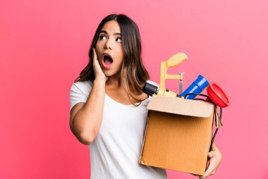 İspanyol güzel kadın mutlu, heyecanlı ve şaşırmış hissediyor. Alet çantası konsepti olan bir hizmetçi.